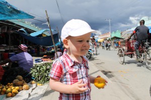 Hilkia bij de markt met een mandarijn